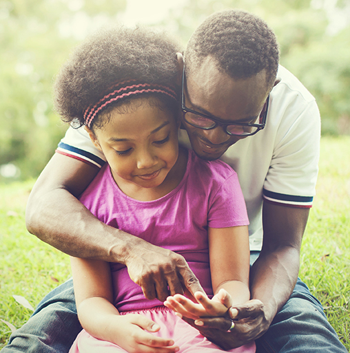 father and child sitting outdoors