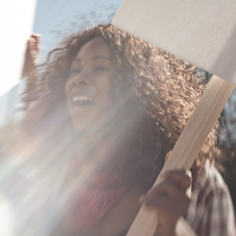 woman-in-sunshine-holding-protest-sign