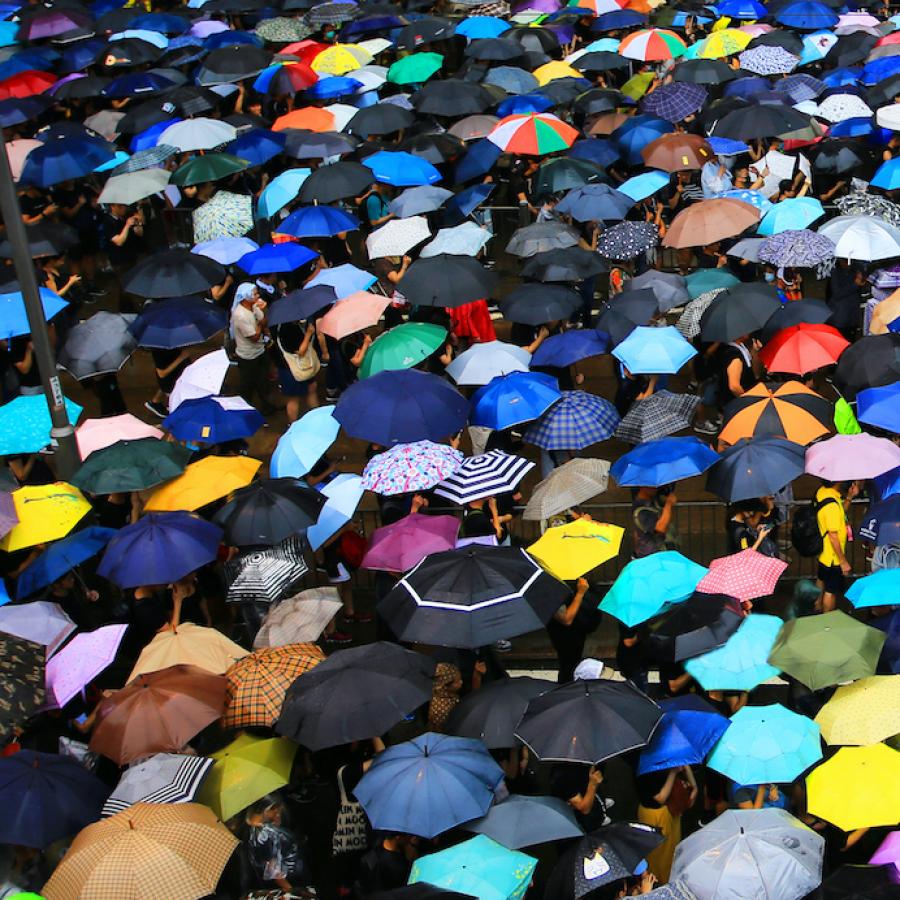 crowds of people protected by umbrellas