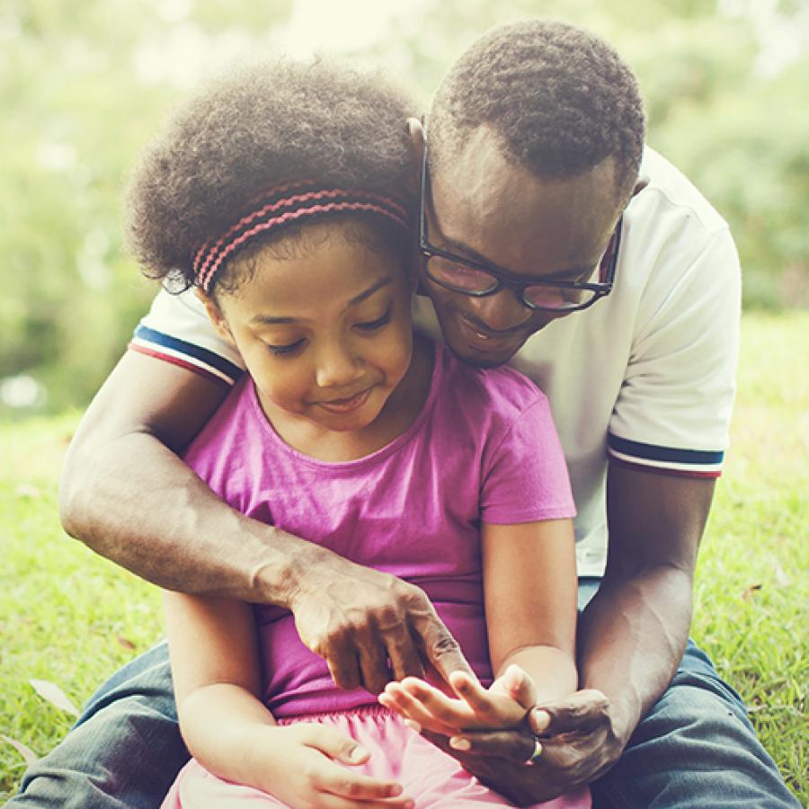 father and child sitting outdoors